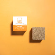 yogh hair volume and shine vegan shampoo bar with amla and orange outside of box on orange background