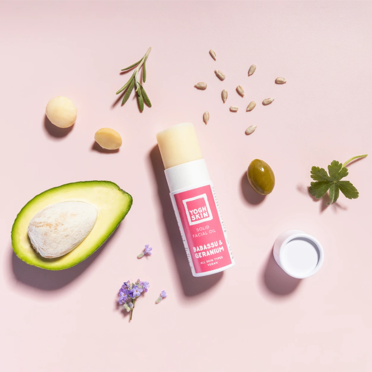 solid facial moisturiser with main ingredients on pink background
