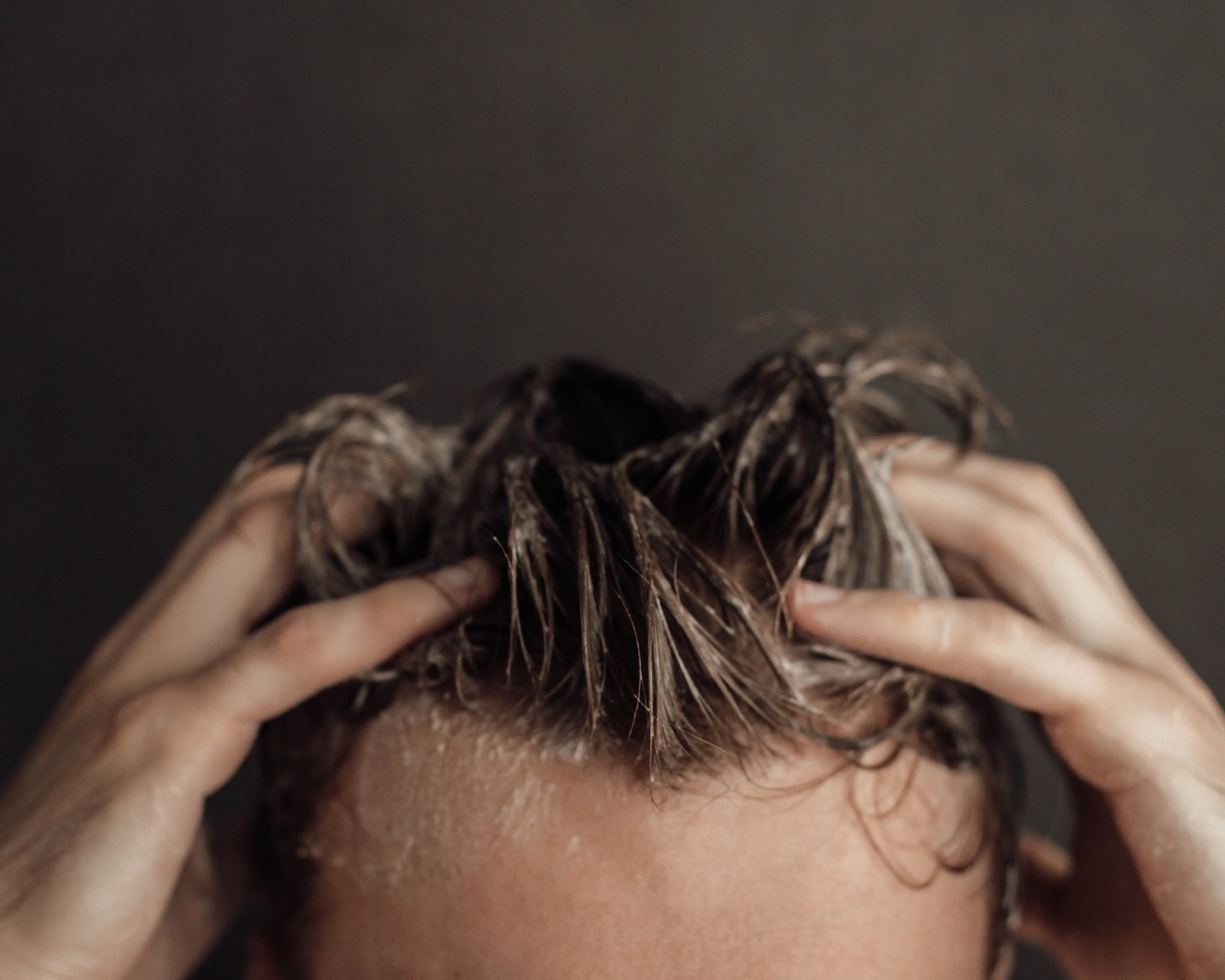 men shampooing his hair with foamy shampoo