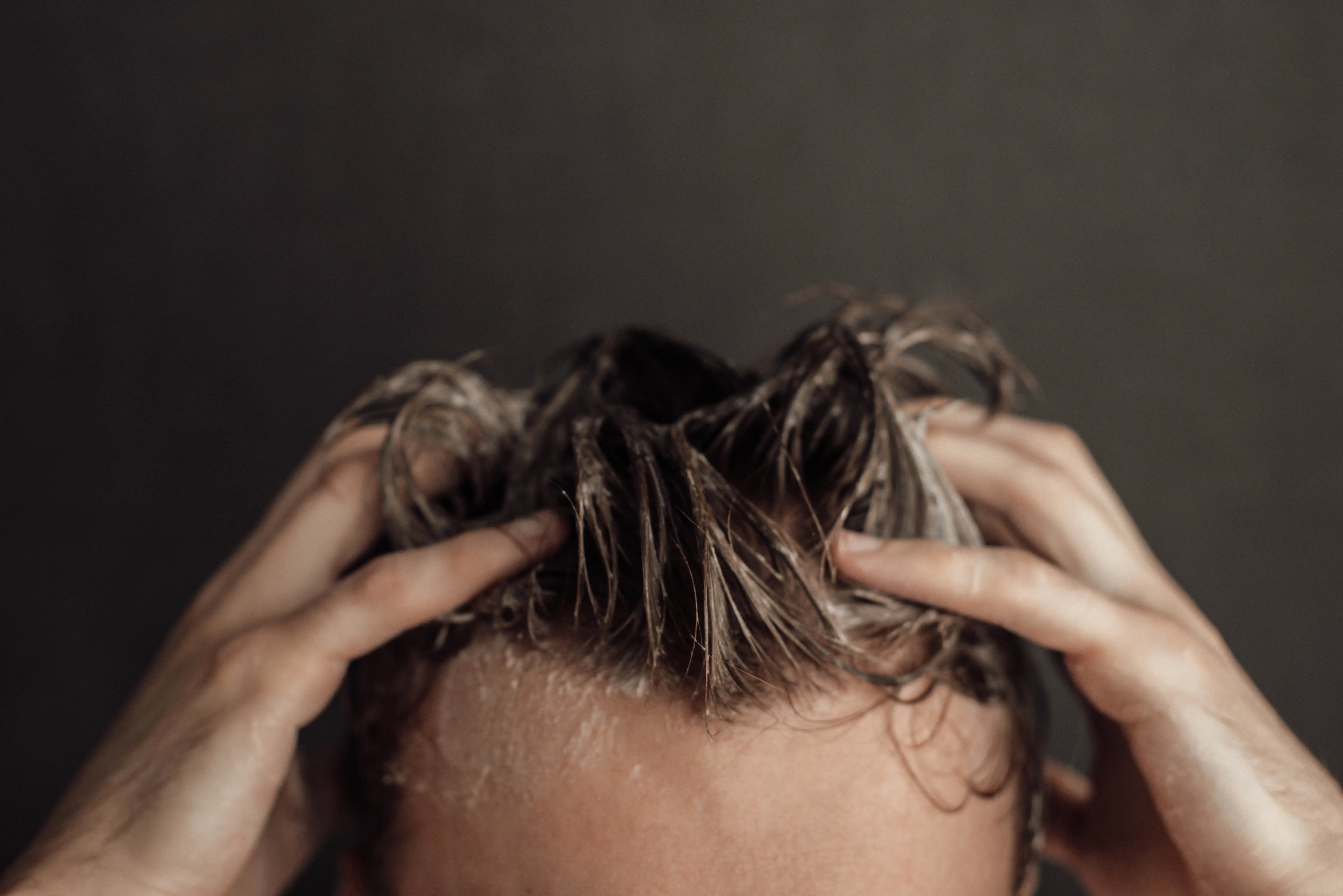 men shampooing his hair with foamy shampoo