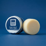 yoghmen solid hair and beard balm next to its packaging on blue background 