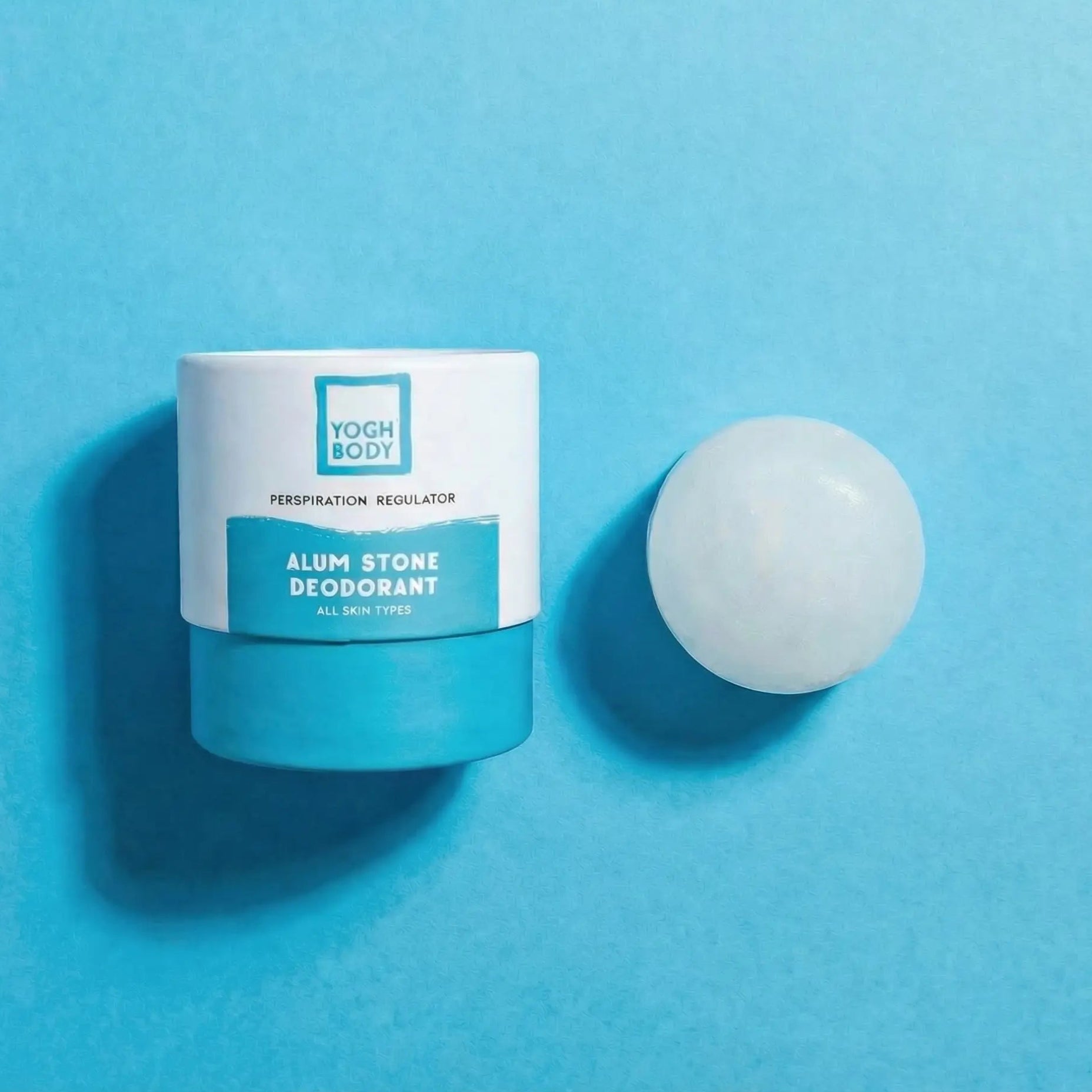 Alum stone deodorant with YOGH packaging on blue background