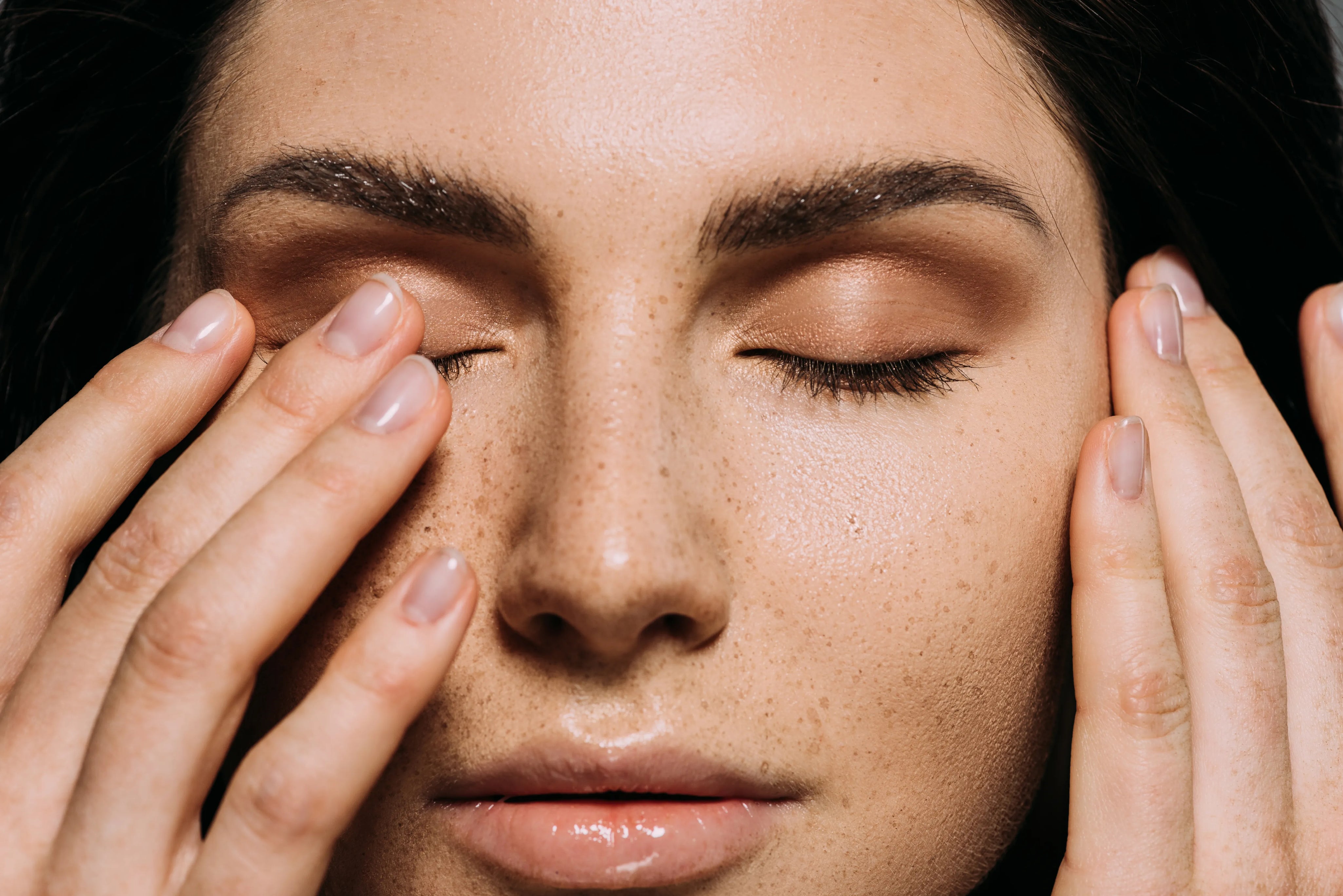 close_up_view_of_tender_girl_with_freckles_on_face_touching_closed_eyes.webp
