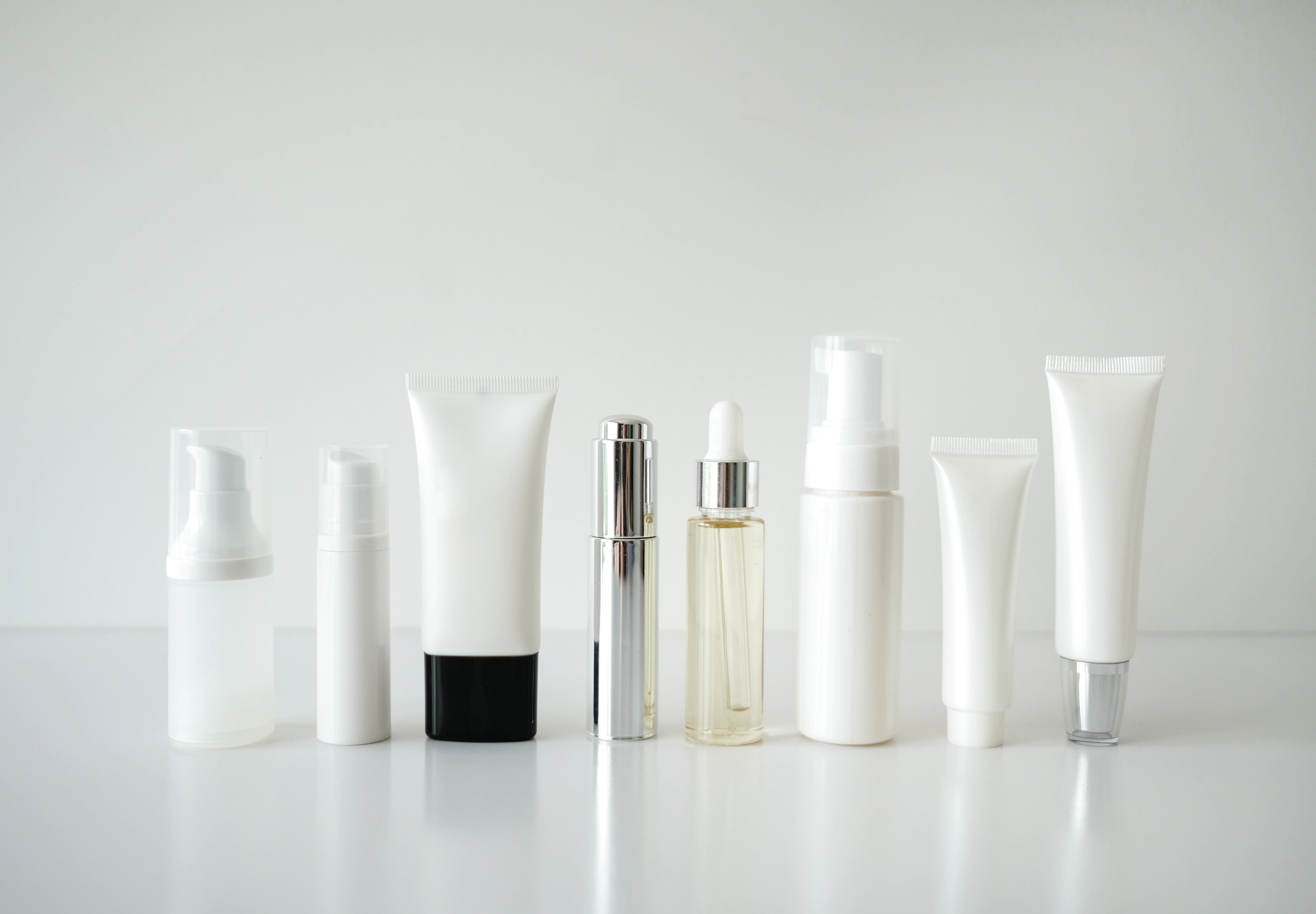 cosmetic products in plastic packaging on white background