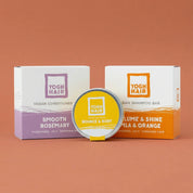 the three products composing the strong hair yoghhair bundle on a soft orange background. the volume shampoo, the thickening conditioner and the hair mask.