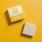 yoghhair honey shampoo next to its packaging on a yellow bakcground