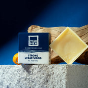 yoghmen conditioner bar for strong hair next to its packaging and active ingredients